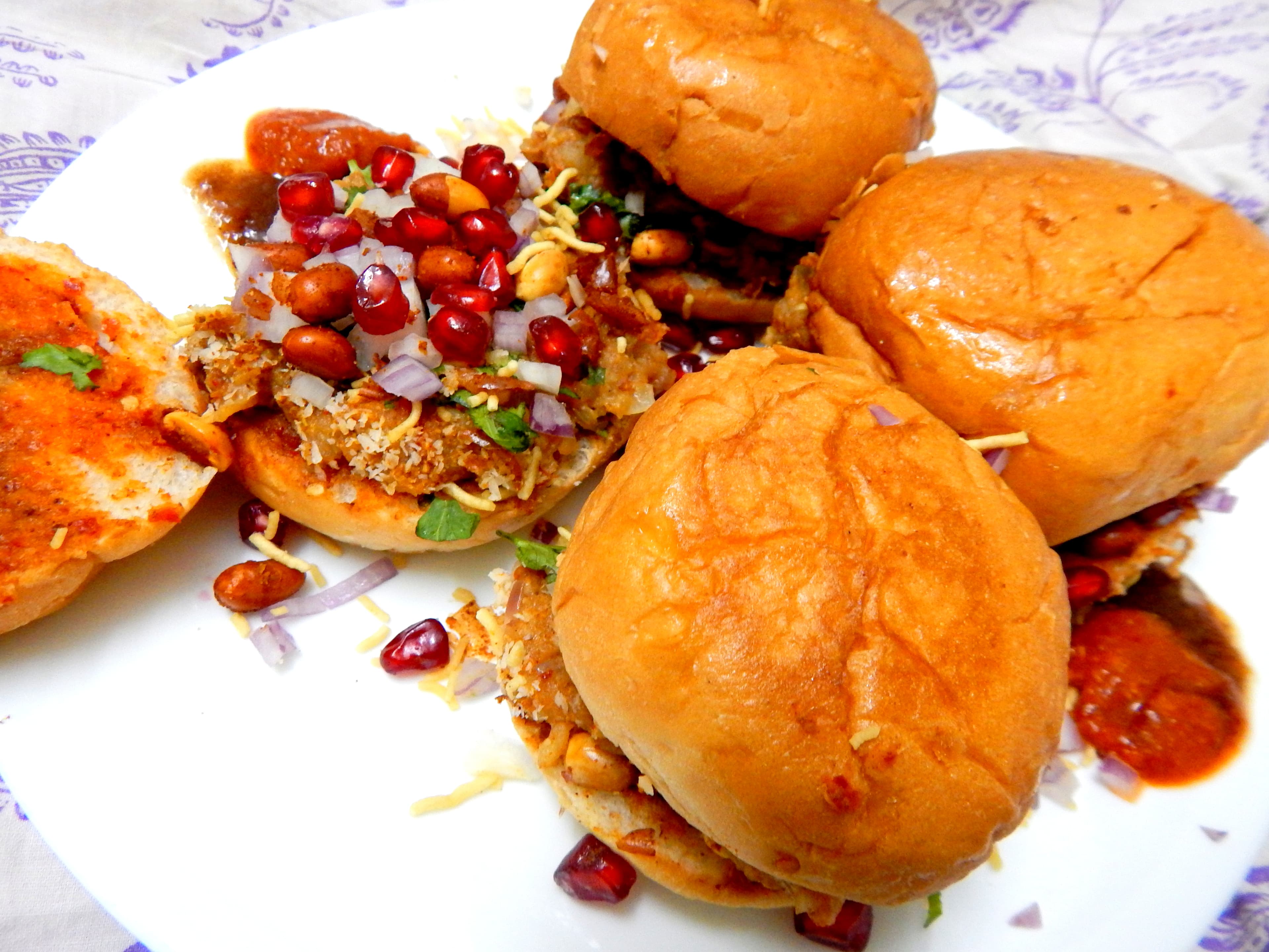 Dabeli — a indian snack dish from India — featuring spiced potato filling, pressed sandwich form, tamarind-date chutneys