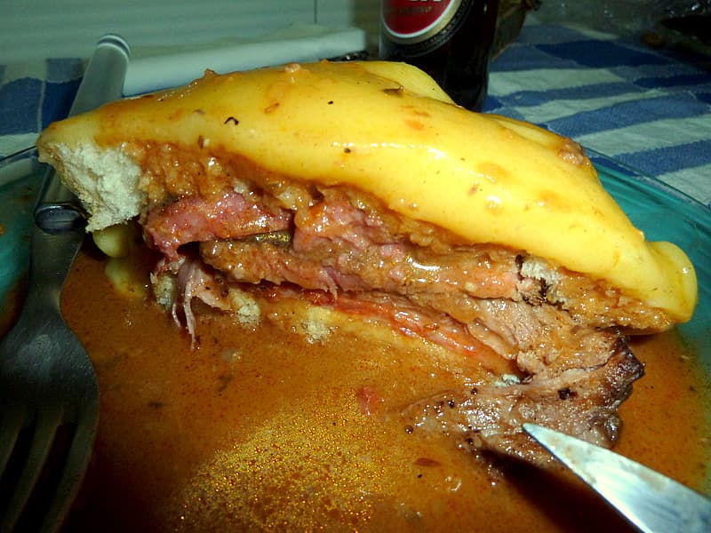 Francesinha — a portuguese main course dish from Porto, Portugal — featuring beer-tomato sauce, cheese sealed, four-meat stack