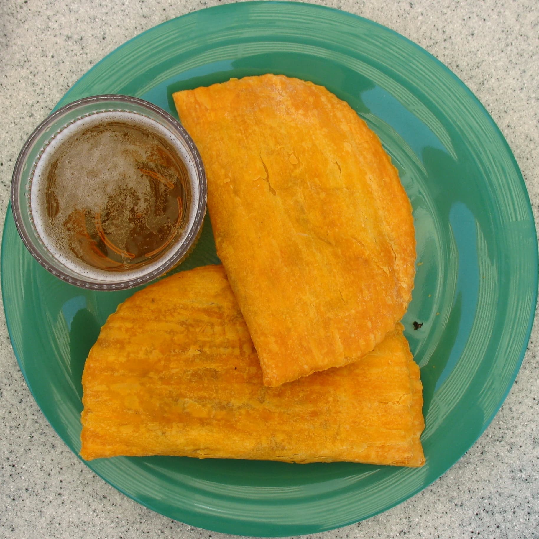 Jamaican patty — a jamaican drink dish from Jamaica — featuring folded turnover, spiced ground meat, flaky crust