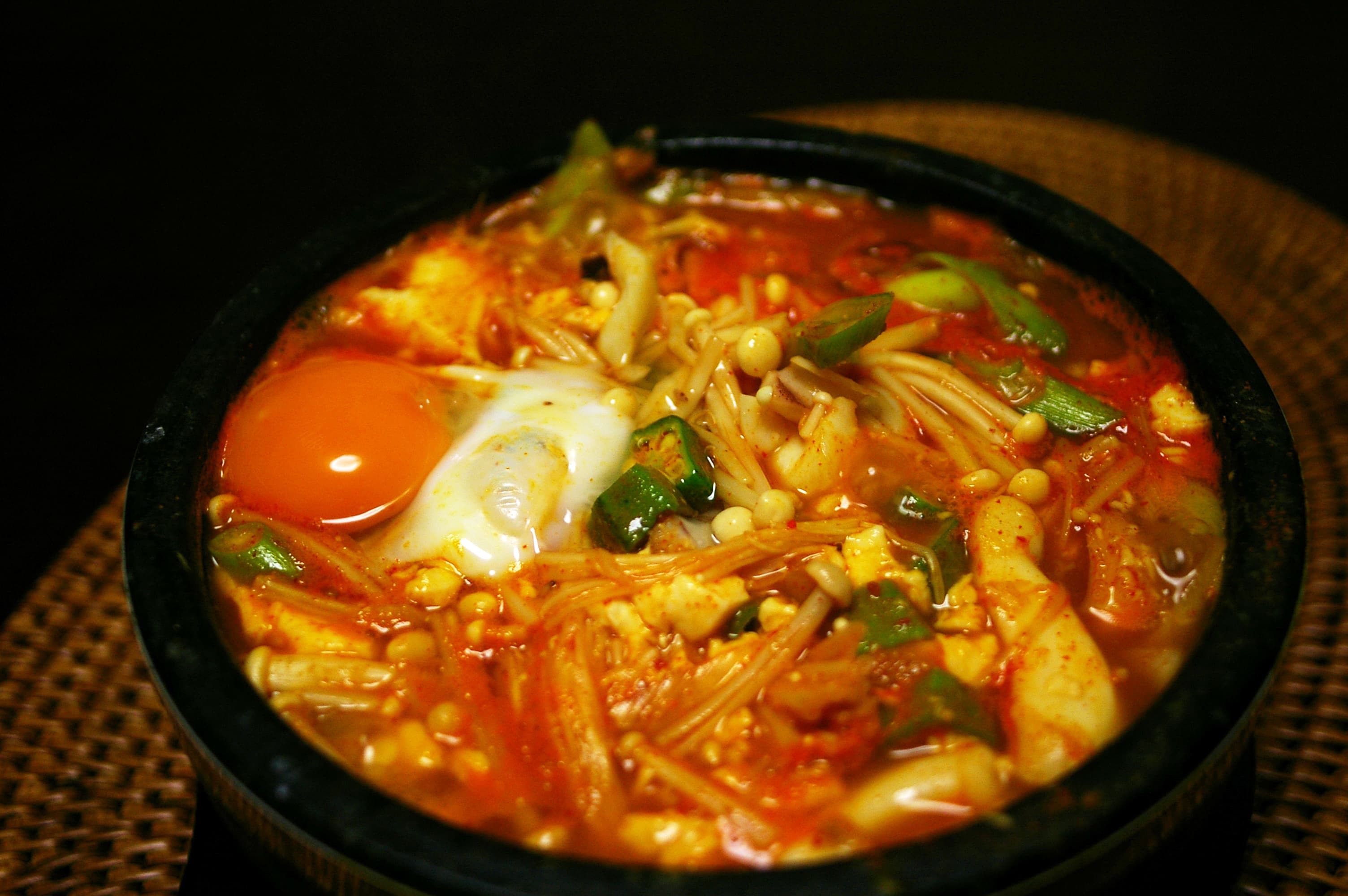 Sundubu Jjigae — a korean main course dish from Seoul, South Korea — featuring silken tofu, still-boiling stone pot, raw egg finish