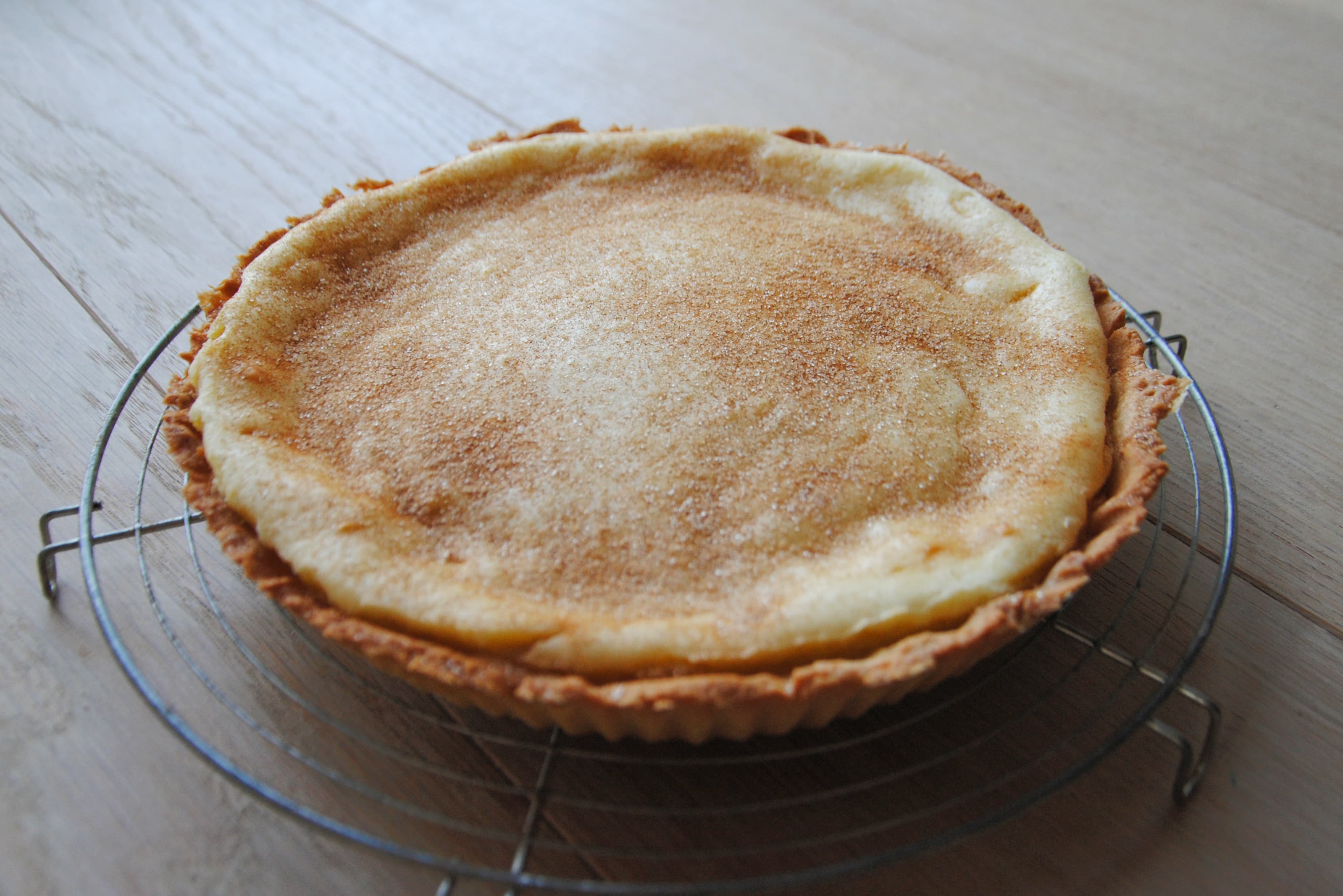 Melktert — a south african dessert dish from South Africa — featuring milk-forward custard, shortcrust pastry, cinnamon-dusted
