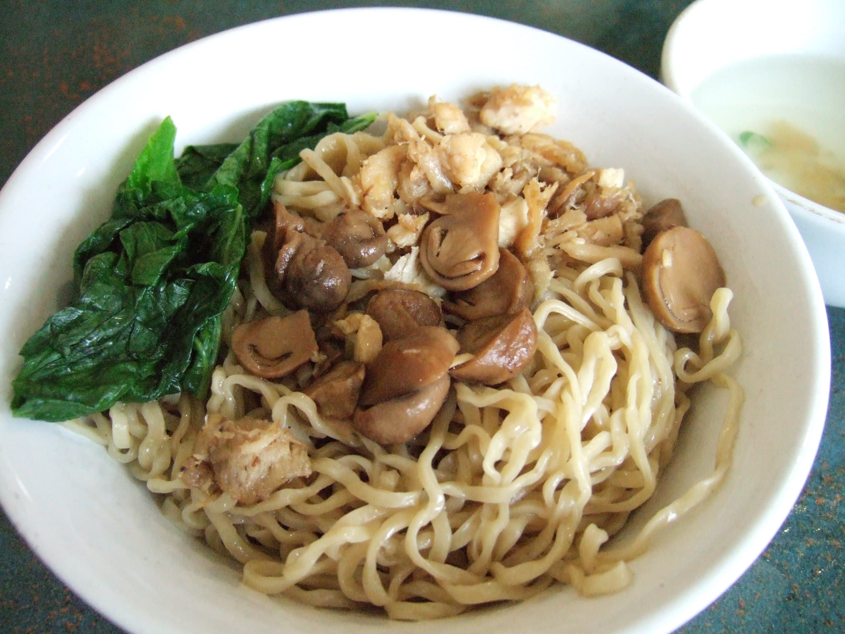 Mie ayam — a indonesian main course dish from Indonesia — featuring yellow wheat noodles, diced chicken topping, Chinese-Indonesian fusion