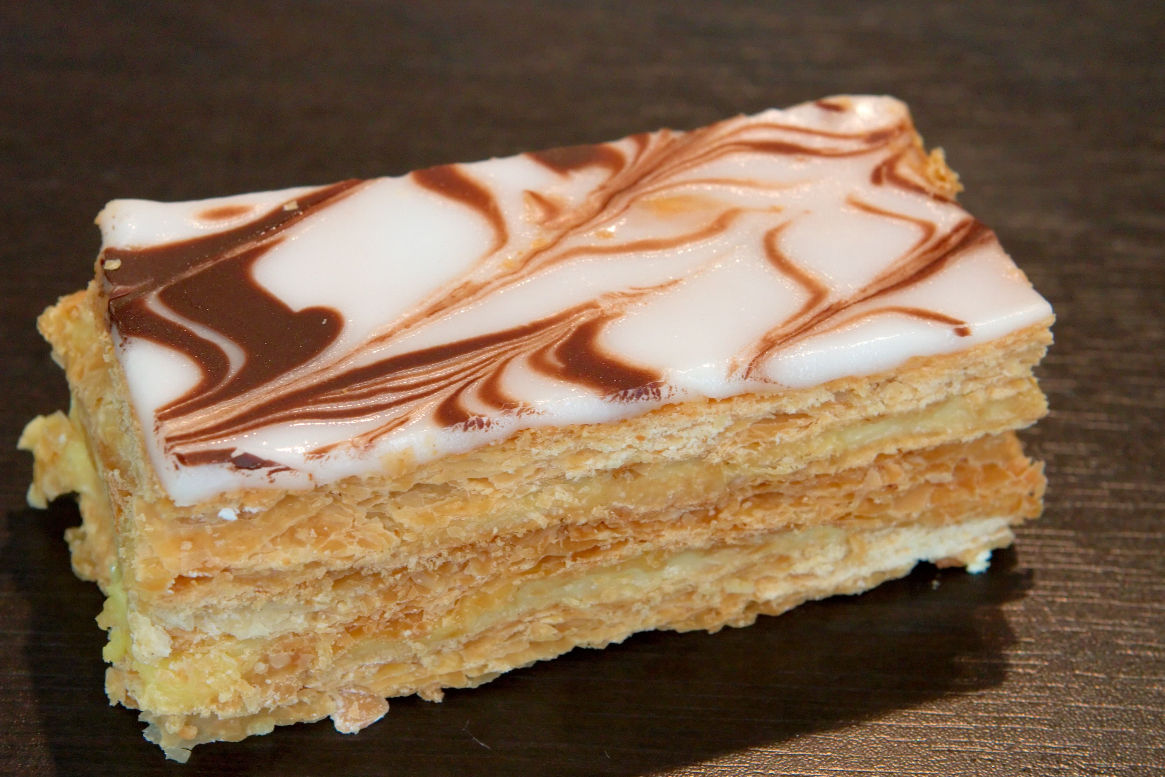 Mille-feuille — a french dessert dish from France — featuring laminated pastry, pastry cream layers, glazed top