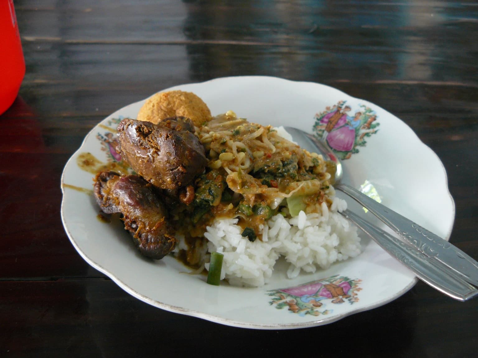 Nasi pecel — a indonesian main course dish from Indonesia — featuring peanut sauce, leafy vegetables, fried tempeh