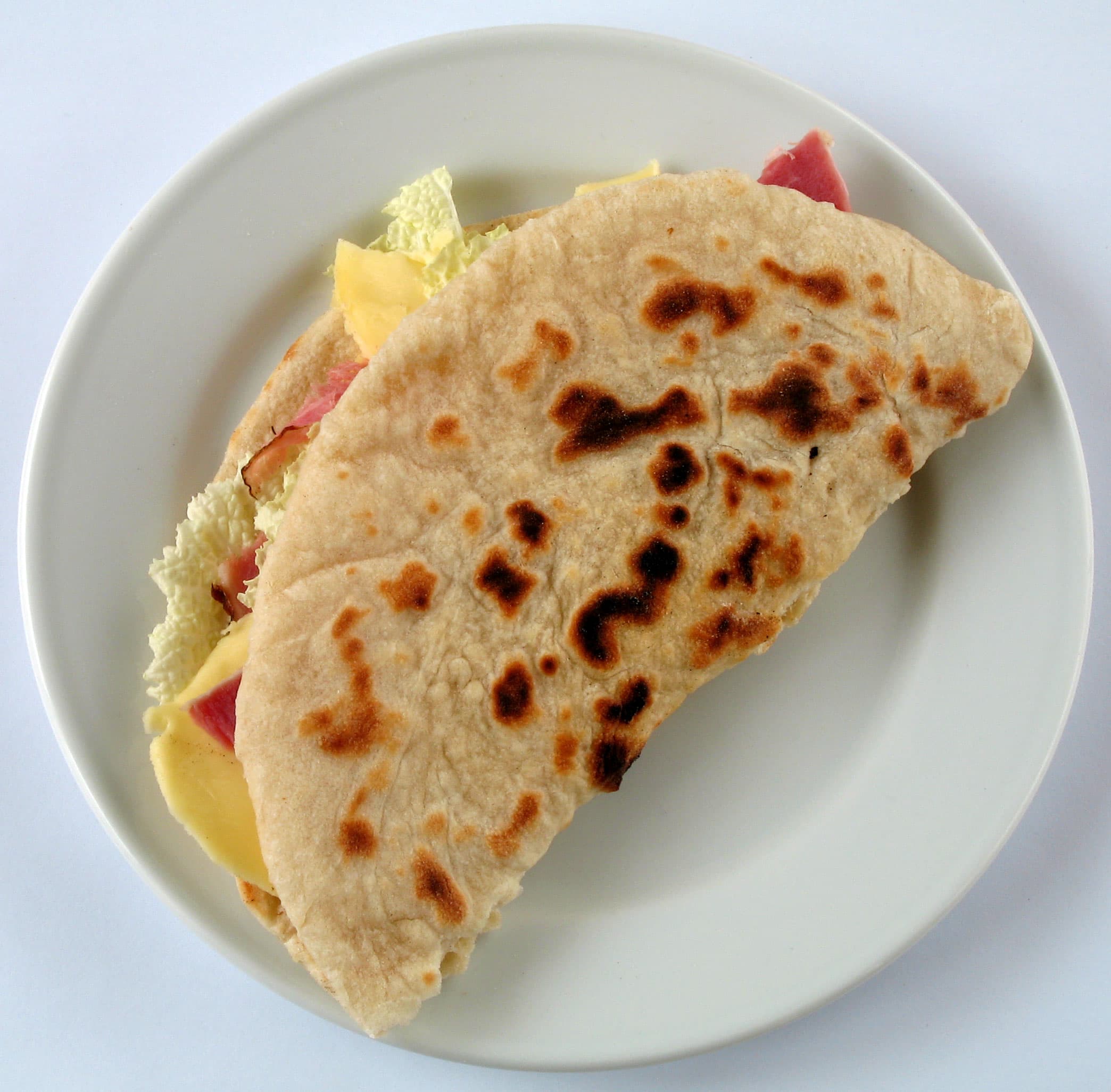 Piadina romagnola — a italian main course dish from Italy — featuring thin flatbread, terracotta-cooked, lard and flour
