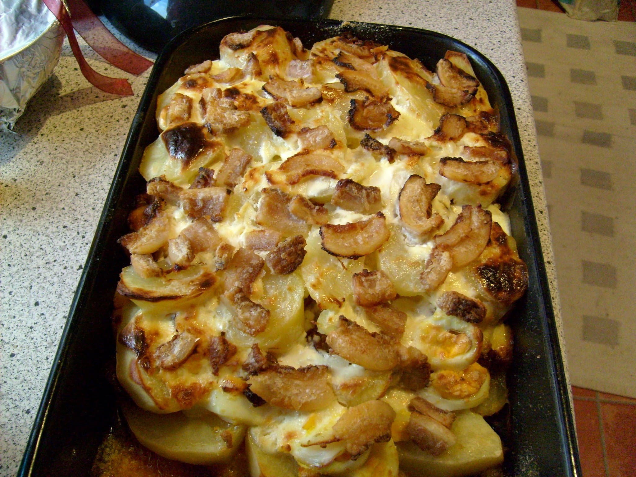 Rakott krumpli — a hungarian main course dish from Hungary — featuring layered casserole, sour cream-based, smoked sausage