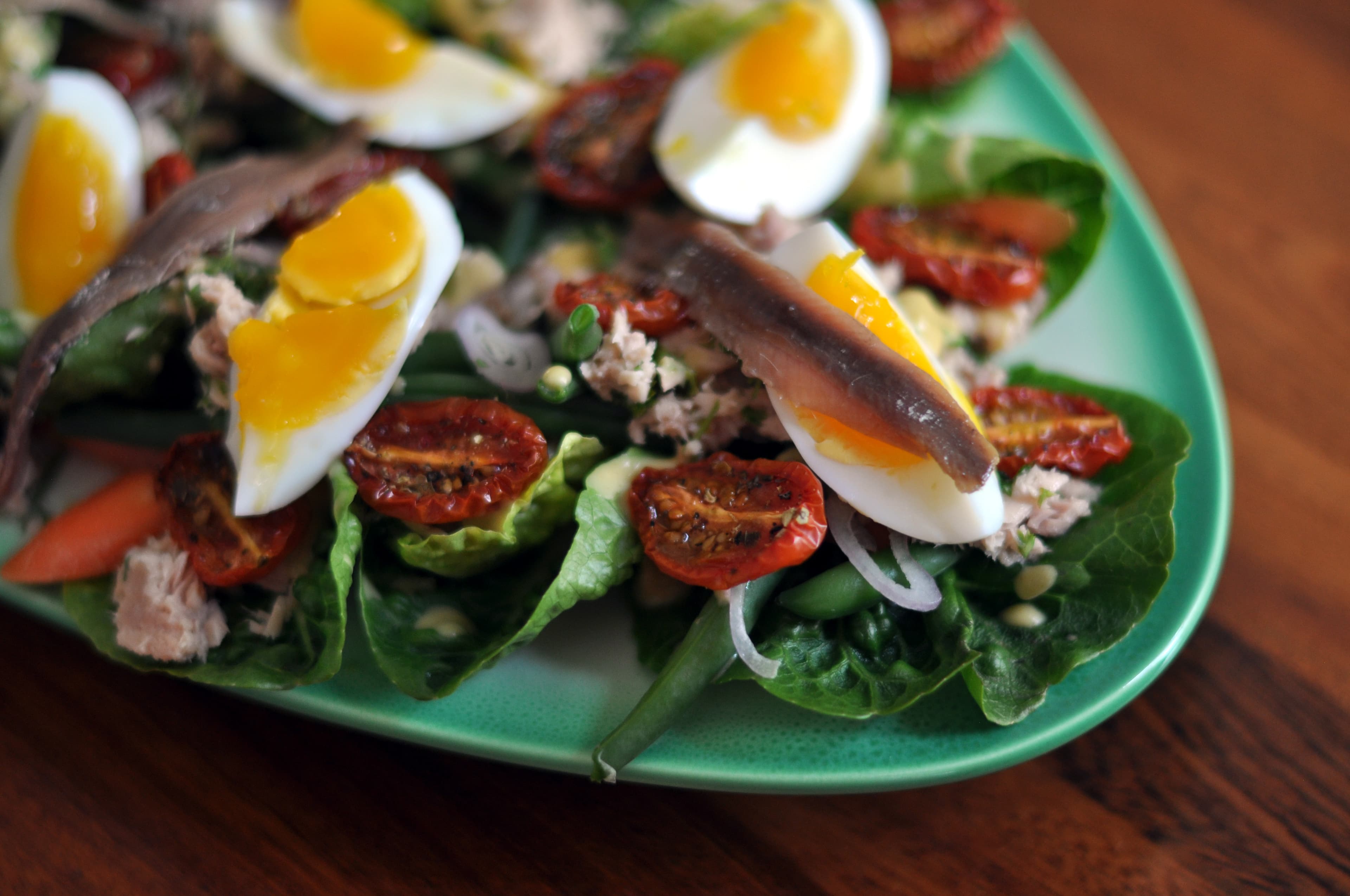 Salade niçoise — a french main course dish from France — featuring composed or tossed, French Mediterranean, eggs and anchovies