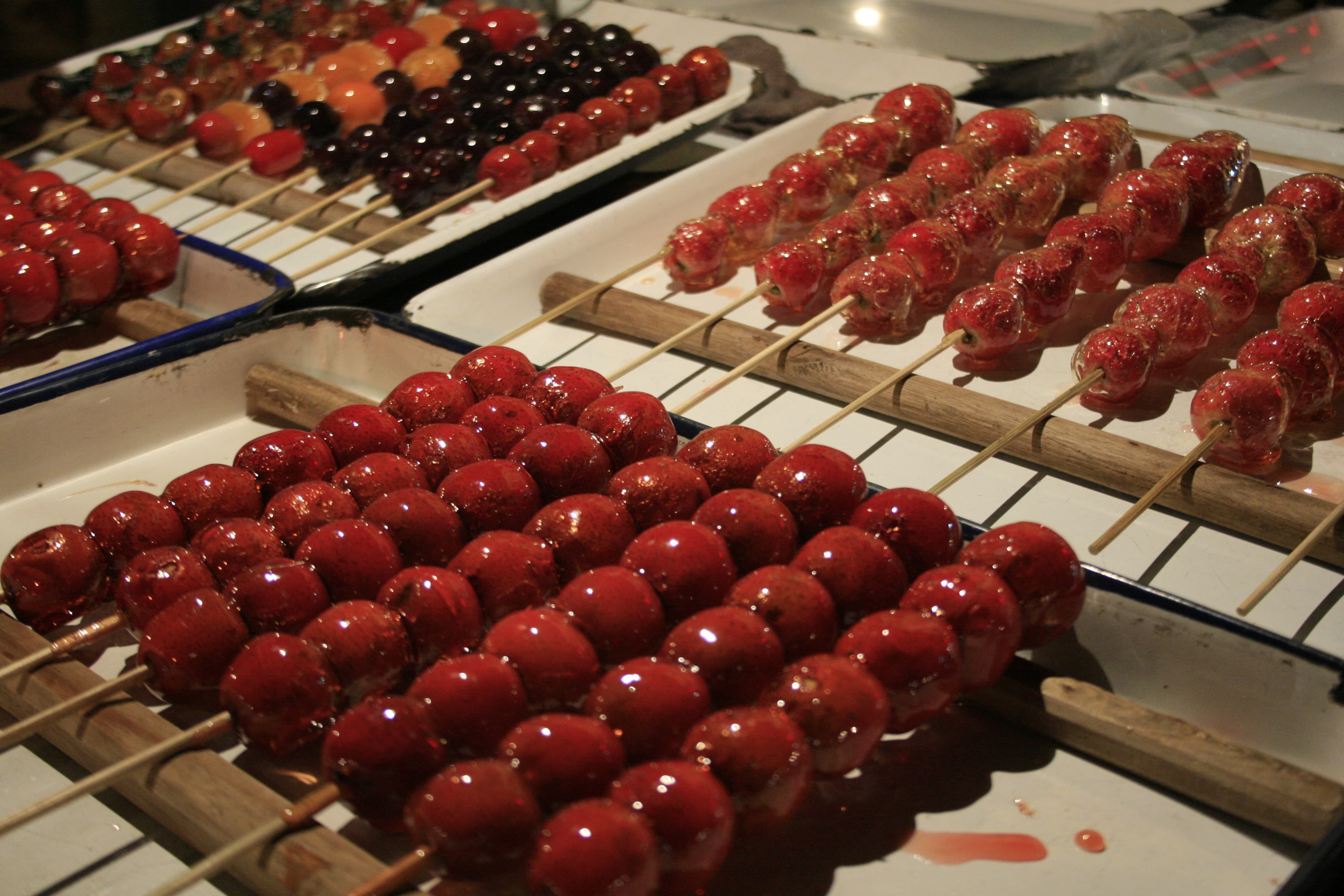 Tanghulu — a people's republic of china cuisine snack dish from People's Republic of China — featuring sugar-shattered candy shell, bamboo-skewered fruit, Song dynasty origin