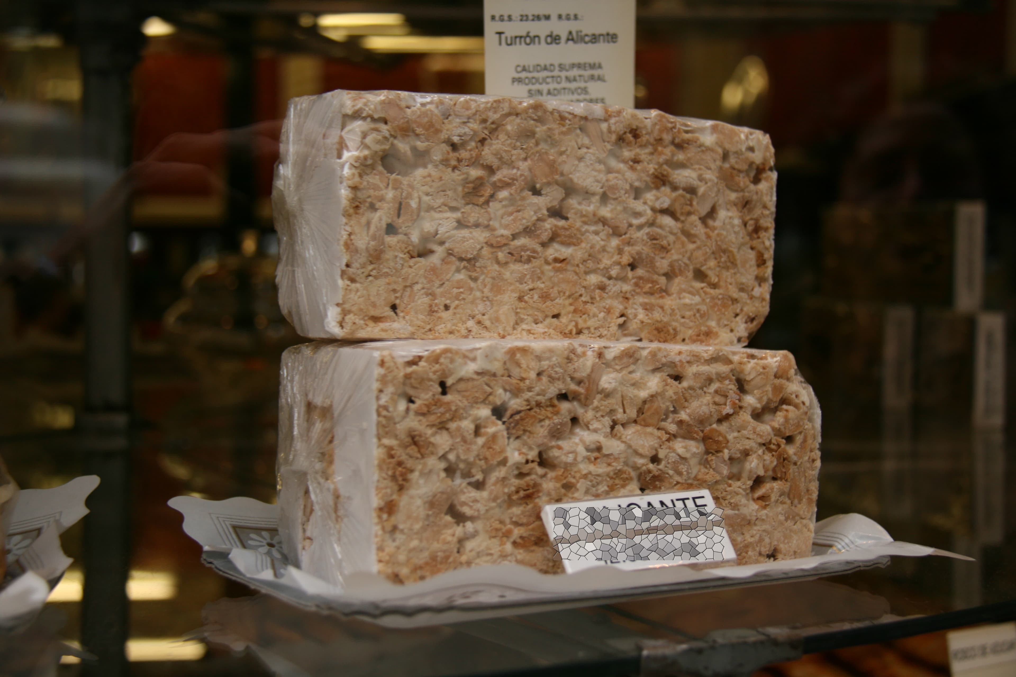 Turrón — a spanish dessert dish from Spain — featuring whipped egg white base, toasted almond studded, tablet-pressed