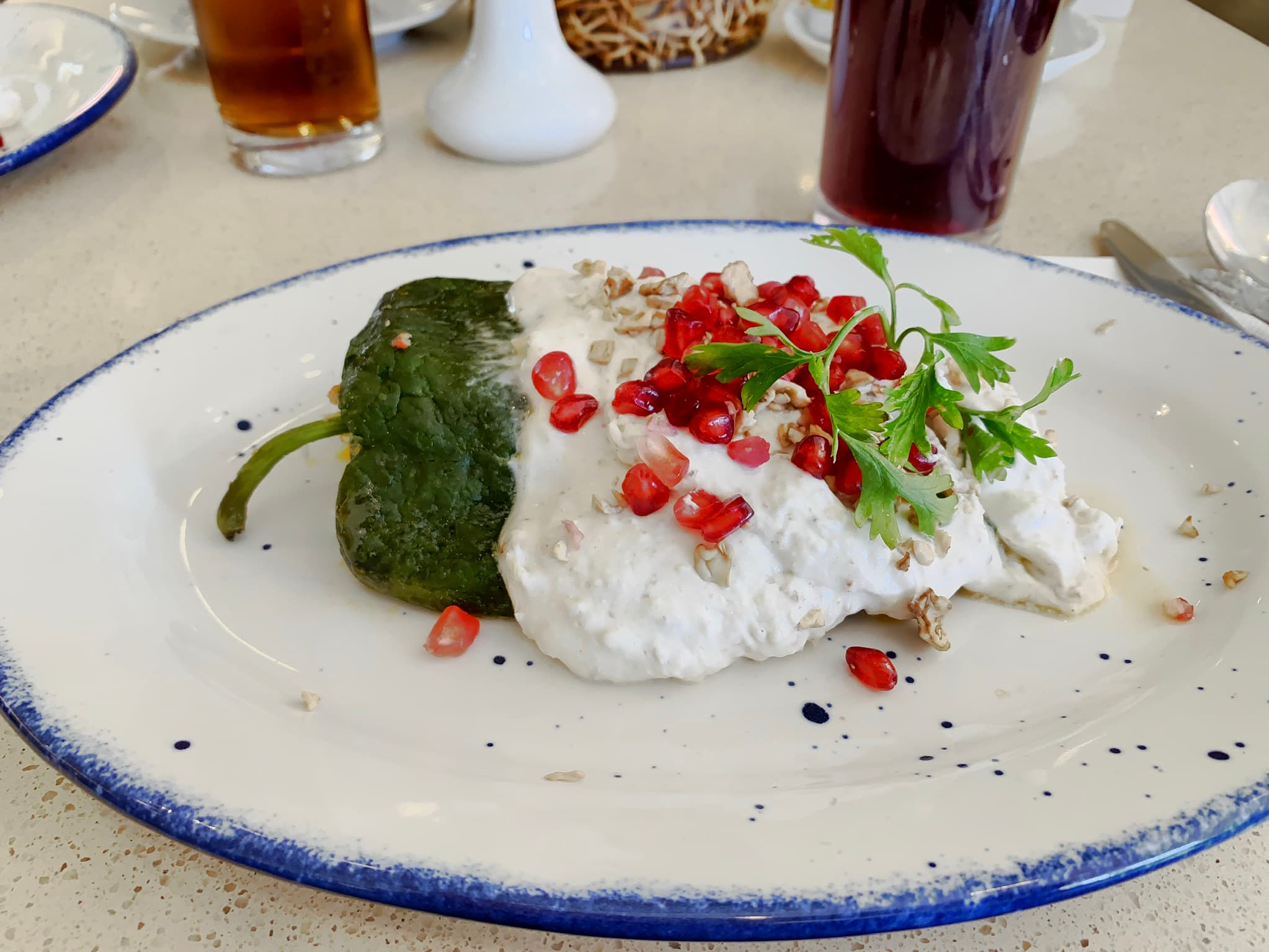 Chiles en nogada — a mexican main course dish from Mexico — featuring poblano-stuffed, walnut cream sauce, fruit-forward picadillo