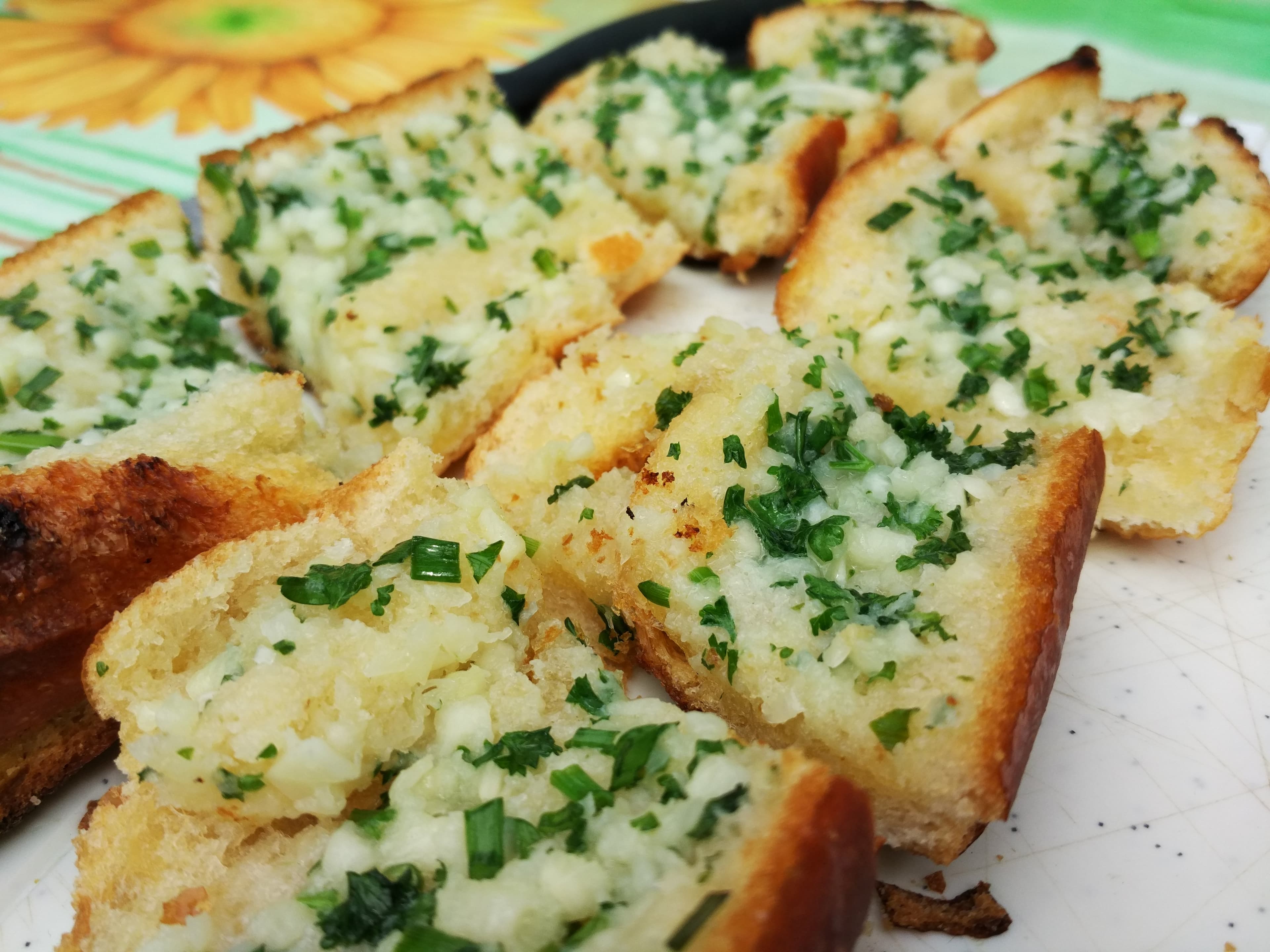 Garlic bread — a italian main course dish from Italy — featuring butter-soaked, herb-topped, baguette-based