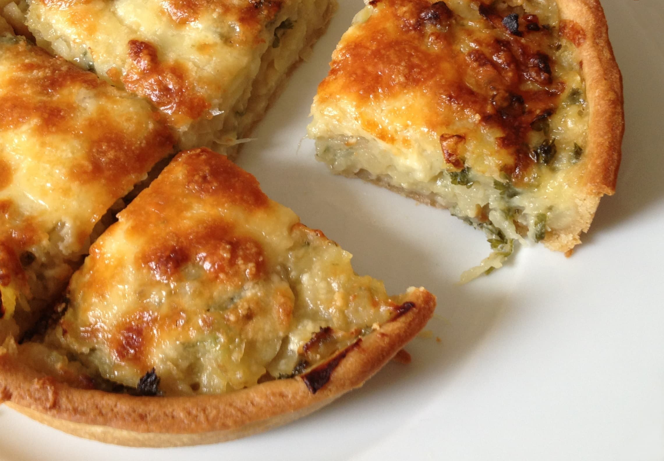 Homity pie — a british main course dish from United Kingdom — featuring open pie, cheese-topped, potato-forward