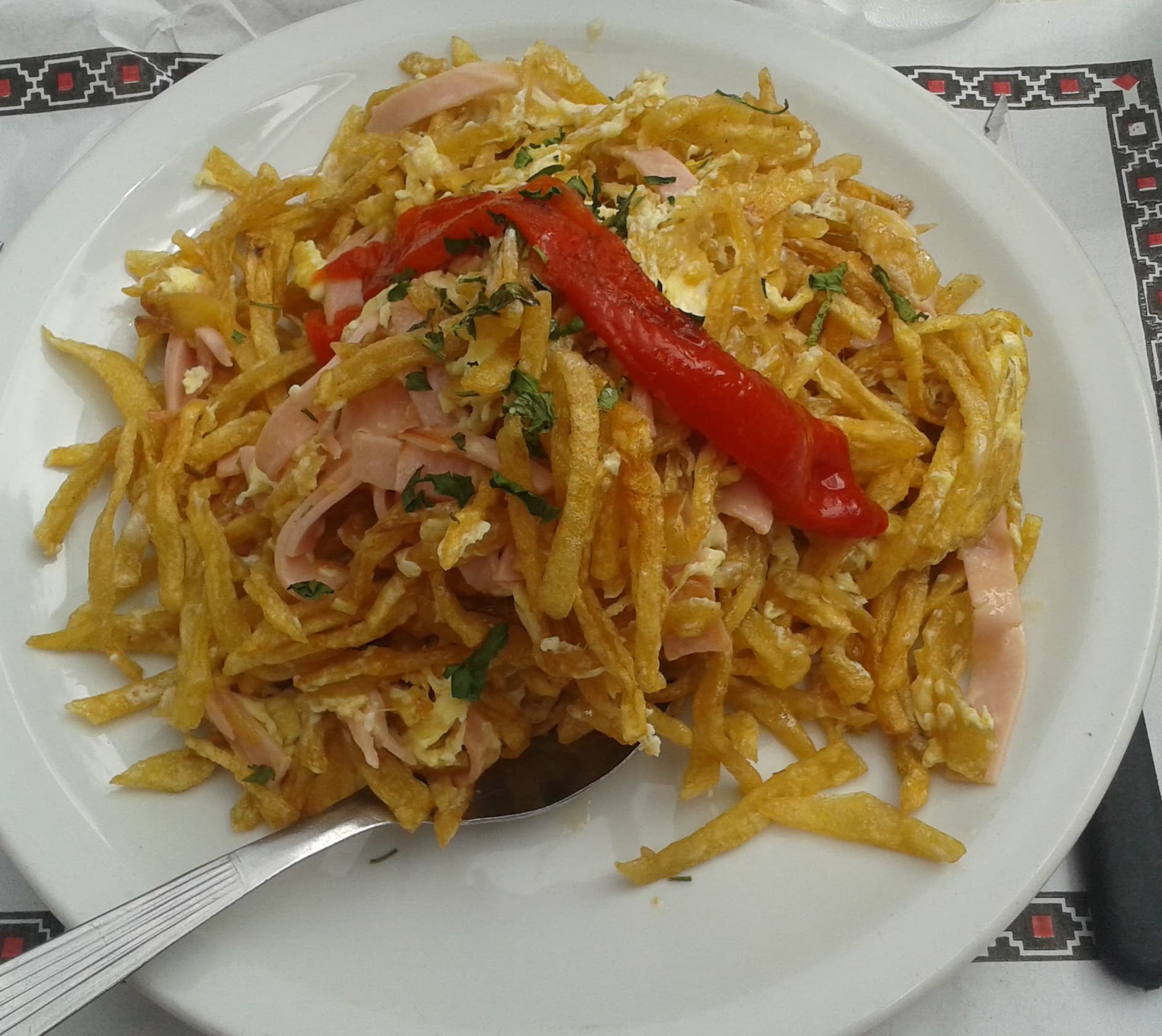 Revuelto Gramajo — a argentine main course dish from Argentina — featuring fried potatoes, eggs, ham-forward