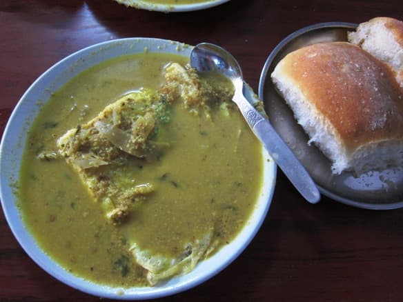 Ros omelette — a indian street food dish from India — featuring poured-over, street cart, gravy-soaked